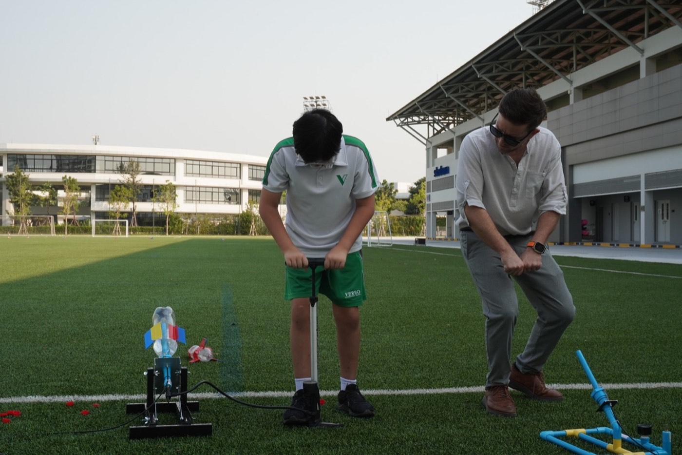 Mr. Dex leaning in to help a student during a Middle Loop class at VERSO International School